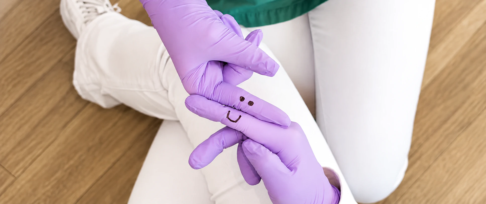 Foto zweier Hände mit bemalten Einmal-Handschuhen